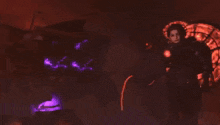 a person is standing in front of a fire with a sword in their hand .