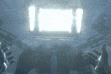 a blurry picture of a person 's hands reaching out towards a light .