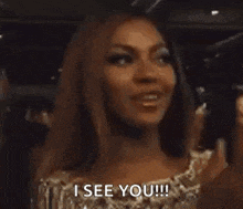 a woman in a gold dress is smiling and says `` i see you '' .