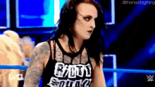 a woman is standing in a wrestling ring wearing a shirt that says bad squad on it .