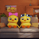 two cartoon ducks are sitting on a couch and holding hands