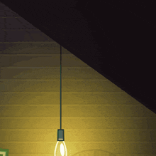 a light bulb hanging from the ceiling with a picture frame in the background
