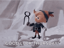 a cartoon elf is standing in the snow holding a pair of scissors .