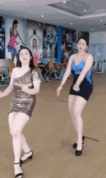 two women are dancing in a gym and one is wearing a sequined dress
