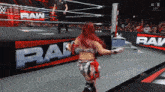a woman in a wrestling ring with the word raw on it