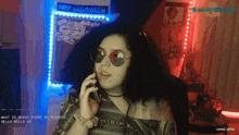 a woman talking on a cell phone in front of a wall that says happy halloween
