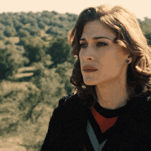 a close up of a woman 's face in front of a forest