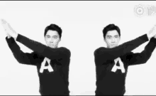 two men wearing sweaters with the letter a on them are standing next to each other .