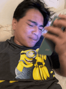 a man wearing a shirt with a picture of a minion holding bananas