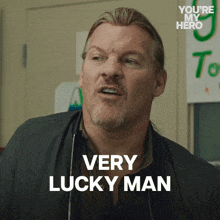 a man says " very lucky man " in front of a green sign that says " you 're my hero "