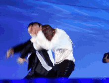 two men are dancing on a stage with a blue sky in the background