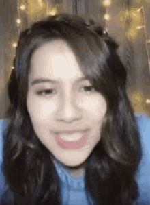a close up of a woman 's face with a blue shirt on .
