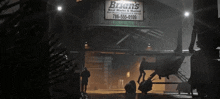 a sign for bryan 's boat works and marina hangs above a helicopter