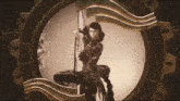 a woman holding a pole in a circle with a greek key pattern