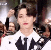 a man in a suit and tie is looking at the camera .