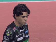 a man wearing a shirt with mikasa volksbank and tecnogas logos