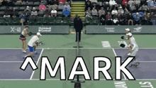 the word mark is on a tennis court with people playing