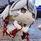 a stuffed doll with a red and white dress and a ribbon around her neck