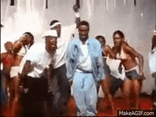 a group of people are dancing in a room .