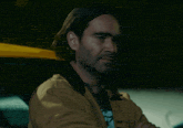a man with long hair and a beard is sitting in a car