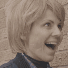 a close up of a woman 's face with a brick wall in the background