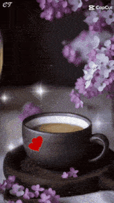 a cup of coffee on a saucer with purple flowers in the background
