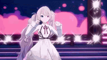a girl in a white dress is standing on a stage with a microphone in her hand .