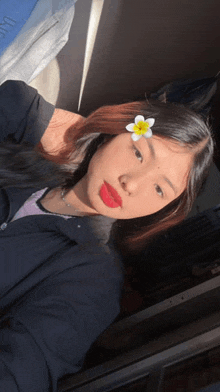 a girl with red lipstick and a flower in her hair takes a selfie