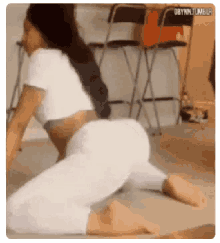 a woman is kneeling on the floor with her legs crossed and her butt visible .