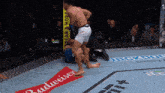 a man in a boxing ring with a budweiser ad on the floor
