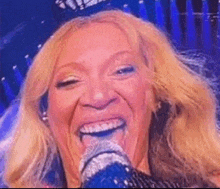 a close up of a woman singing into a microphone .