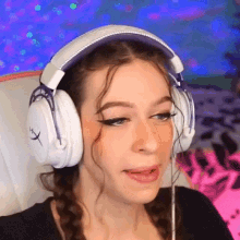 a woman wearing a pair of hyperx headphones makes a funny face