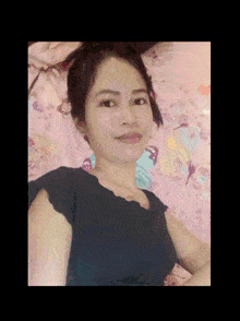 a woman in a black shirt is laying on a bed with butterflies on the sheets