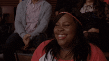 a man in a blue cardigan sits next to a smiling woman