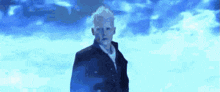 a man in a suit and tie is standing in front of a blue background .