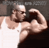 a man in a white tank top is flexing his muscles while wearing glasses .