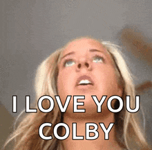 a blonde woman says i love you colby in front of her face