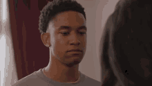 a young man is looking at a woman in a room and making a face .