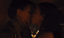 a man and a woman kiss in front of candles