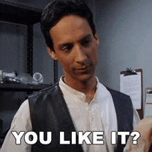 a man wearing a leather vest and a white shirt says " you like it "
