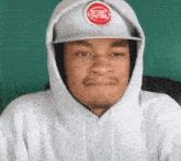 a man wearing a white hoodie and a detroit pistons hat