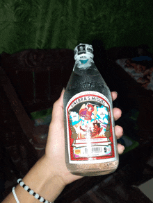 a person is holding a bottle of ginebra 's miguel in their hand