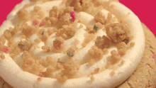 a cookie with white frosting and crumbs on top
