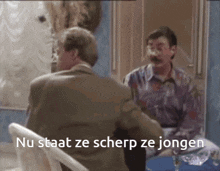 two men are sitting at a table with the words nu staat ze scherp ze jongen written on the bottom