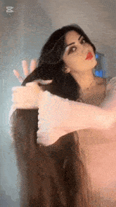a woman with long hair is taking a selfie with her phone .