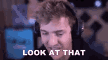 a man wearing headphones is sitting in front of a computer screen .
