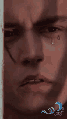 a close up of a man 's face with a tear in his eye
