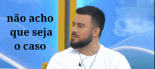 a man with a beard is sitting in front of a blue sky with the words não acho que seja o caso above him