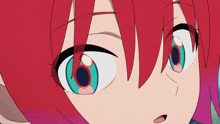 a close up of a girl 's face with red hair and green eyes