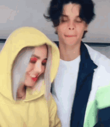 a man and a woman are standing next to each other and making funny faces .
